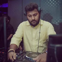 Deep in concentration, mixing tracks. Being a DJ is more than just playing music; it's about the technical skill of blending different genres like House, Hip Hop, and Bollywood to create a unique live set.