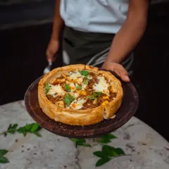 A freshly baked Puffizza, ready to be served. The golden crust and generous toppings make it a visually appealing and delicious addition to any party menu.