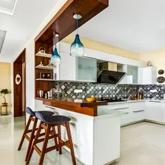 Our modular kitchens combine sleek aesthetics with smart functionality. This design features a stylish breakfast bar with pendant lighting, patterned backsplash tiles, and handleless white cabinets for a clean, contemporary look perfect for modern living.