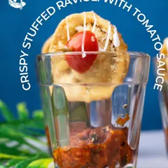 This Crispy Stuffed Ravioli is served in a shot glass over a slow-cooked tomato relish, creating a delightful contrast of texture and temperature.
