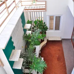 A top-down view of the courtyard in the Prabhakar Residence shows a creative use of a narrow space. We designed a vertical garden with staggered planters to transform it into a lush green feature visible from multiple levels of the home.