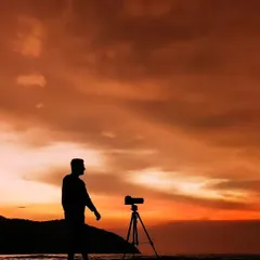 A silhouette of me with my camera on a tripod, setting up a shot against a beautiful beach sunset. This is where I feel most at home, behind the lens.