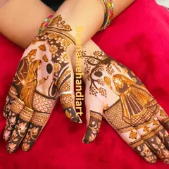 A matching pair of hands for Karva Chauth, showing the complete story of the wife seeing her husband after sighting the moon. The floral patterns around the portraits add a soft, beautiful touch.