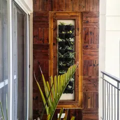We designed this balcony with a custom vertical garden set within a reclaimed wood panel frame. This solution brings a significant amount of greenery to a small space, creating a beautiful natural view for the adjoining dining area.
