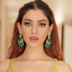 Another close-up of the Haldi look, showing the flawless makeup and how the green earrings pop against the yellow.