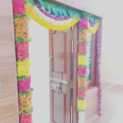 A close-up view of our traditional door decoration. We use fresh flowers like roses and marigolds to create these dense, colorful garlands that make the entrance feel special and welcoming.