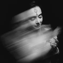 The same artistic bridal portrait, presented in timeless black and white. This version emphasizes the emotion and form, turning the motion blur into a graceful sweep of light and shadow.
