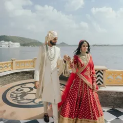 Nikita and Rishabh walk hand in hand along the lakeside in Udaipur, the city's iconic white architecture creating a stunning backdrop for their love story.