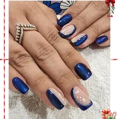 A winter wonderland on your fingertips. This holiday design features a deep, starry blue polish combined with a sheer glitter base and delicate, hand-painted white starbursts.