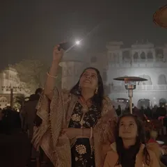 A mother and daughter watch a wedding drone show, their faces filled with wonder. We create moments that are not just for the couple, but for every generation present.