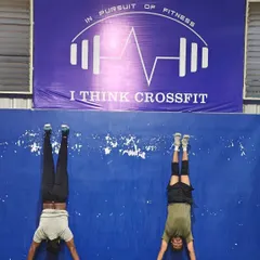 A different kind of strength. Two members practice their handstand holds against the wall, a foundational gymnastics movement that builds shoulder stability and core control.