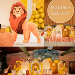 A grand Lion King themed party stage. This setup includes a large Mufasa cutout, a "Hakuna Matata" sign, and a backdrop designed to look like the African savanna.