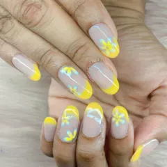A cheerful and sunny design. We created a modern French manicure with bright yellow tips and added delicate, hand-painted yellow and blue daisies on the clear base for a fresh, floral look.