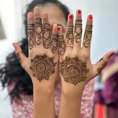 A simple and classic mandala design on the palms. The fingers are adorned with delicate vines and lines, creating a look that is both traditional and understated.