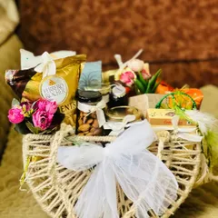 A beautiful wedding gift hamper in a rustic jute bag. It's filled with Ferrero Rocher chocolates, premium nuts, and other gourmet treats, finished with a delicate white net bow.
