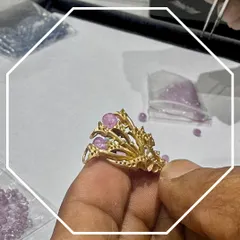 Craftsmanship is also about bringing color to life. In this shot, you can see our artisan carefully setting pink gemstones into a unique, branch-like gold structure. This behind-the-scenes look shows the precision required to handle delicate stones and create a balanced, artistic design.