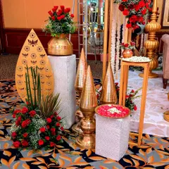 A close-up of traditional decor elements. I used ornate brass pots, golden spires, and fresh red roses to create this beautiful arrangement, adding an authentic and auspicious touch to the wedding decor.