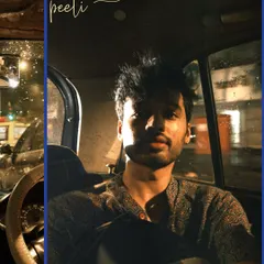 A self-portrait during a 'kaali peeli' ride at night, the city lights creating a dramatic play of light and shadow.