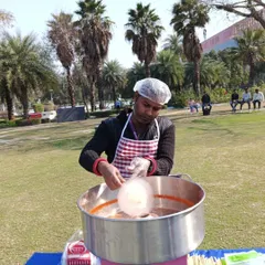 My operator skillfully spinning a cloud of cotton candy. I handle the entire process, from setup to serving, so you don't have to worry about a thing.