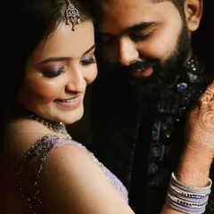 A tender embrace that highlights the bride's beautiful mehendi and engagement ring. Her joyful smile and the couple's closeness make this a perfect candid shot, full of warmth and happiness.