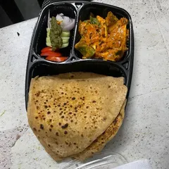 This is a typical daily meal featuring soft, homemade chapatis made from 100% chakki fresh atta. It's paired with a delicious paneer sabzi and a crisp salad for a balanced and nutritious tiffin.