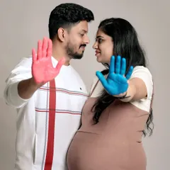 Another creative take on a gender reveal photo. This image uses colored paint on the couple's hands to create a memorable and artistic announcement.