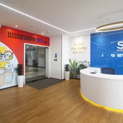 The reception desk for Scientific Games is set against a glossy blue wall with the company logo. A "Namasakara SG" mural on the adjacent wall adds a local greeting and cultural touch, making the space feel welcoming.