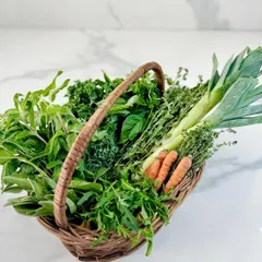 A 'FarmLove' basket brimming with the season's best produce from our farm. This includes fresh leeks, mint, baby carrots, kale, and a variety of herbs, all grown using chemical-free practices.