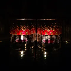 This pair of lamp chimneys features a red and gold pattern. The warm colors create a wonderfully rich and festive glow, ideal for Diwali celebrations.