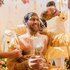 The Haldi ceremony is all about unrestrained joy, and sometimes, a little bit of madness. This shot of the groom being drenched by his friends captures the true spirit of our documentary style: real, fun, and completely unposed.