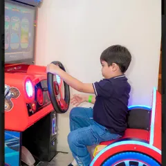 A young guest concentrates on the screen as he enjoys a racing game in our arcade section.