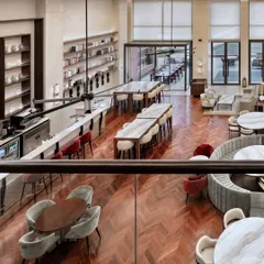 An overhead view of the Elevate Clubhouse restaurant, highlighting the open, multi-level layout. The design promotes visual connection between the ground floor and the mezzanine, creating a dynamic and socially engaging atmosphere.