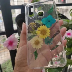 This custom phone case features a bright and cheerful arrangement of real dried flowers, including yellow daisies and blue hydrangeas, with a sprinkle of gold flakes.
