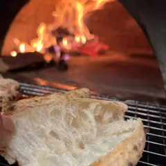 This is where the flavour is born. Our Neapolitan crust, with its soft, airy pockets, getting that perfect fire-kissed char from the wood oven. It's a difference you can taste.