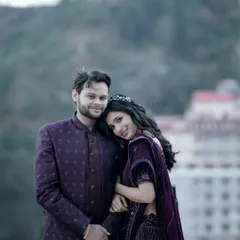 A closer portrait of the couple, where her smile lights up the frame as she leans into him. The soft focus on the background architecture emphasizes their joyful connection, making it a perfect shot for capturing the happiness of a pre-wedding getaway.