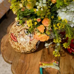 Details are everything. For the Haldi, I incorporated playful, handcrafted artifacts like this painted face vase and tiger clapper, adding a touch of whimsy and celebrating the work of local Indian artisans.