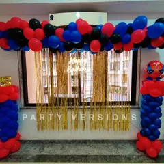 A simple yet effective Spiderman balloon decoration for a fan's birthday. The setup includes balloon pillars and a backdrop with gold fringe, perfect for a superhero celebration at home.