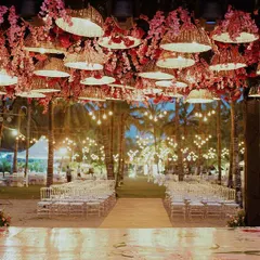 Beach weddings are a whole VIBE. ❤️ For this evening ceremony, we created a canopy of woven basket lamps and pink blossoms, casting a warm, romantic glow over the aisle as dusk settled in.
