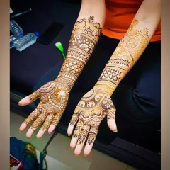This full-arm design showcases a beautiful lotus on one palm and elephants on the other, blending symbolic motifs with classic Indian mehandi art.