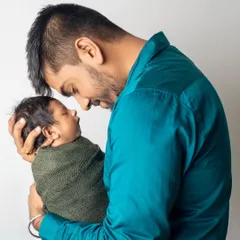 A father's love. This tender moment between a new dad and his sleeping baby captures the profound connection and emotion of early fatherhood.