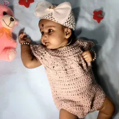 This sweet baby girl is wearing a custom crochet romper I made. The delicate stitch pattern and cap sleeves make it a lovely and comfortable piece for portraits or special family events.