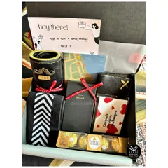 A personalized hamper for him, featuring a custom beer mug, a wallet, naughty couple's challenges, and his favorite chocolates.