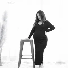 A simple and elegant black and white portrait. The high-key lighting and minimalist setting put all the focus on the mother-to-be and her beautiful silhouette.