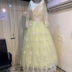 This pastel lime ballgown offers a classic princess silhouette. The bodice is covered in delicate white floral embroidery that extends down the full tulle skirt, making it ideal for a reception.