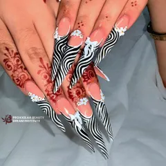 Another view of the zebra stiletto nails, this time with added 3D white bows and floral clusters at the cuticle for an extra touch of feminine detail.
