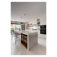 The kitchen island provides ample workspace and storage, with integrated wooden baskets for easy access to everyday items.