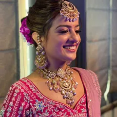 Every jewel tells a story, and today, this JBR Bride is the most radiant chapter. She is wearing a full bridal set, including a polki necklace with pastel drops, matching jhumkas, and a maang tikka.