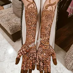 A classic and elegant full-hand bridal design. The pattern is dense with floral and paisley motifs, and the fingertips are fully covered, which is a traditional element that gives a very rich look.