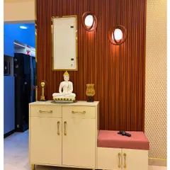 This foyer area includes a beautiful console table with a Buddha statue, creating a serene and welcoming mandir space right at the entrance of the home.