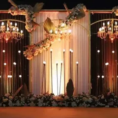 A sophisticated Black Rose Gold theme for a sangeet ceremony. The stage features elegant chandeliers, warm candle lights, and lush floral arrangements, creating a perfect blend of modern style and romance.